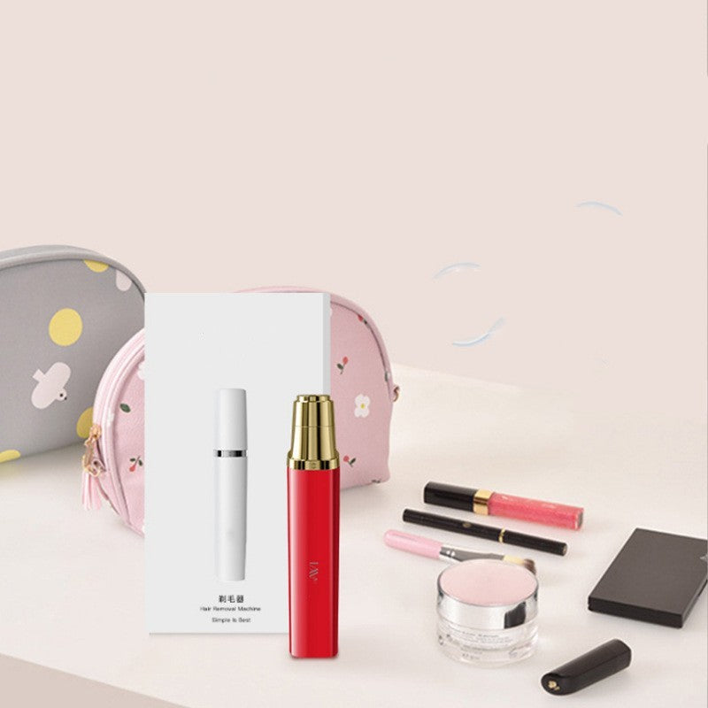Portable face hair trimmer in red and white, surrounded by makeup products and cosmetic bags.