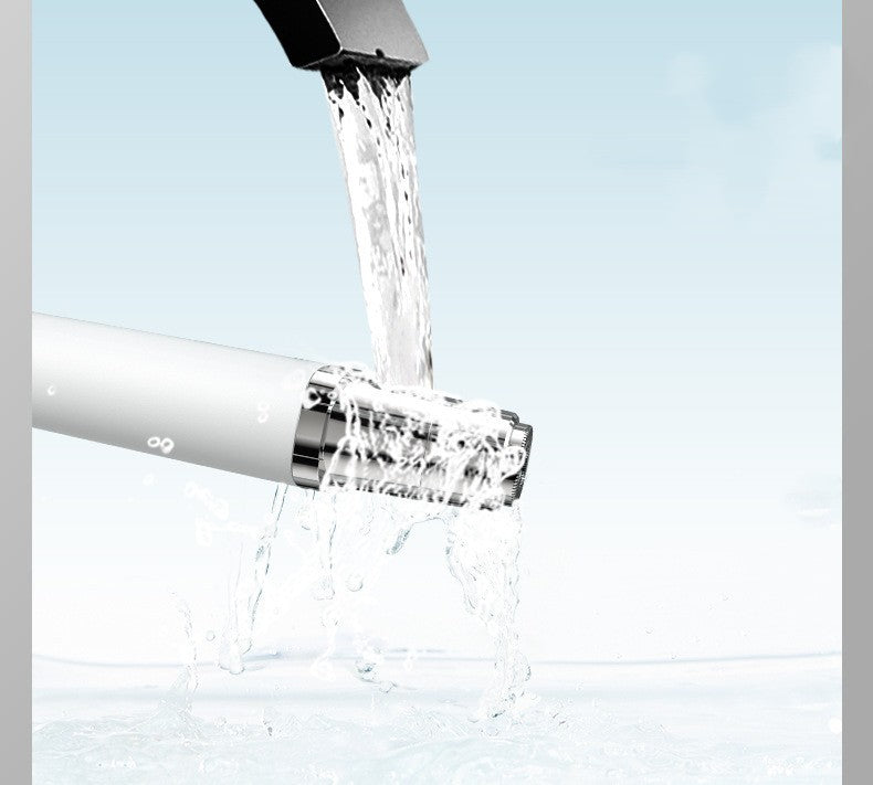 Water splashing over a portable face hair trimmer in a clean and bright environment.